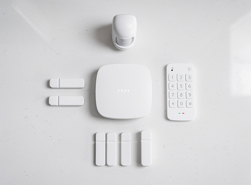 Smart home security system on a kitchen counter with sensors and base station, no subscription contract paperwork visible