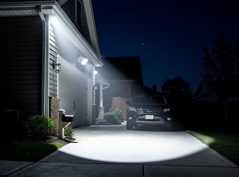 Smart motion-activated floodlight illuminating driveway at night