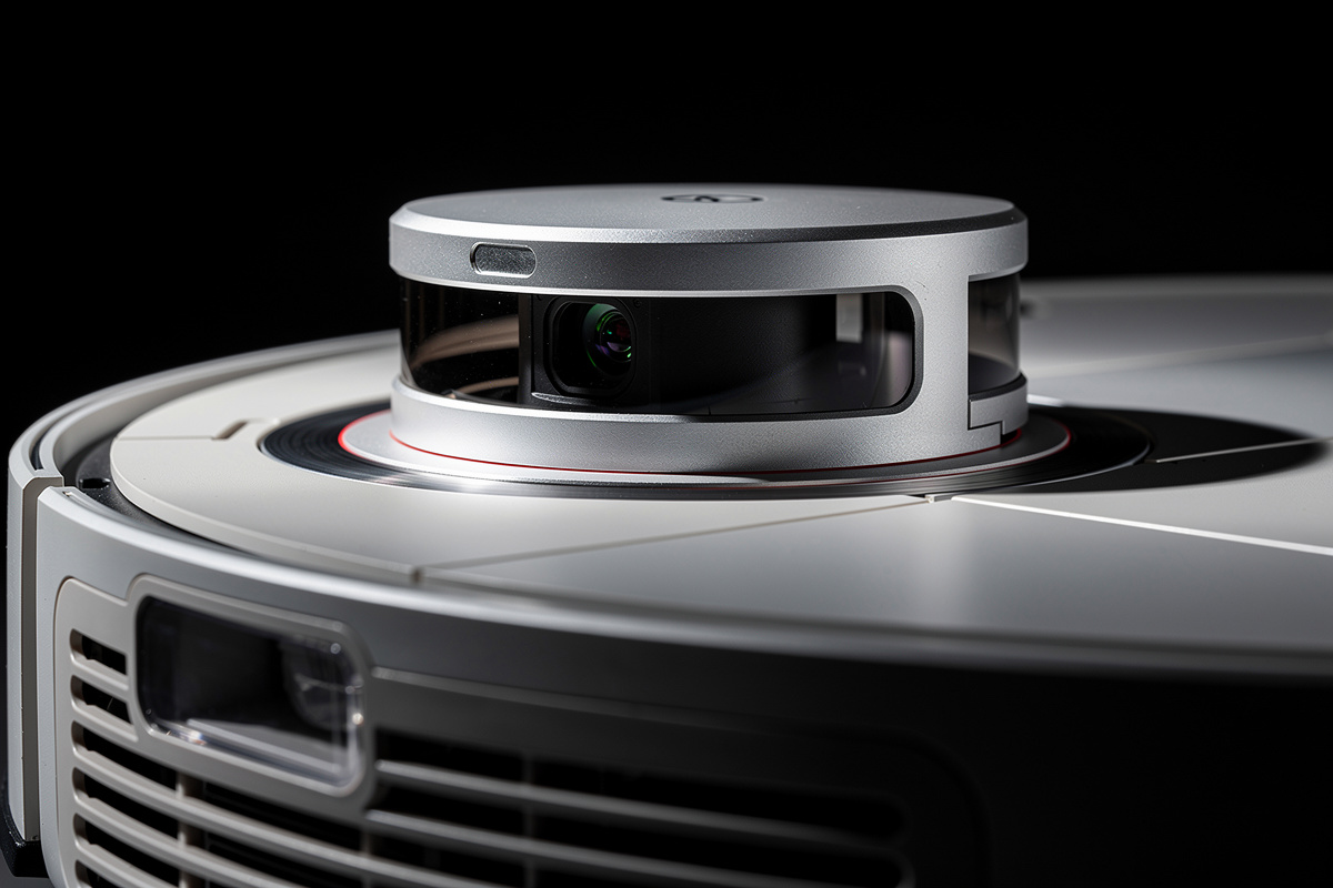 Close-up of robot vacuum LiDAR turret spinning laser sensor with dramatic side lighting