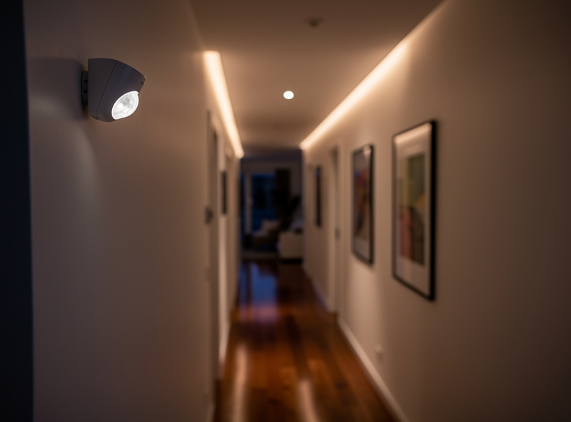 Motion sensor triggering automated lighting in smart home hallway