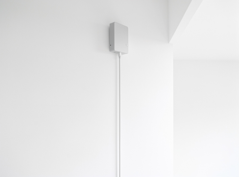 A network Zigbee coordinator mounted on a wall on an Ethernet cable, away from other electronics