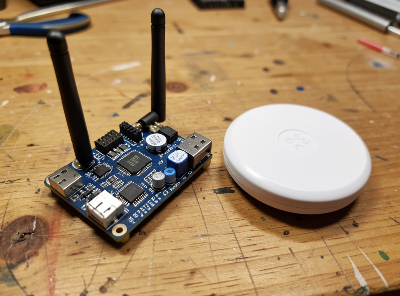Close-up of a Zigbee coordinator stick and mmWave presence sensor on a workbench