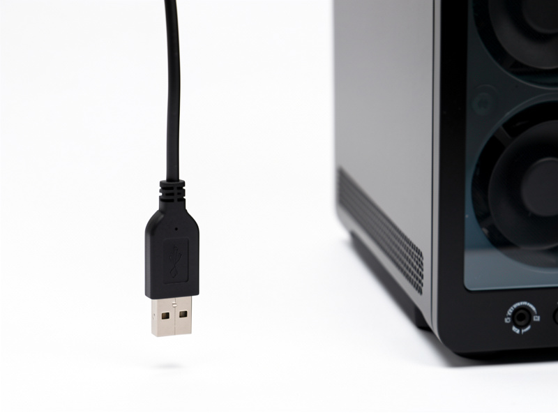 A Zigbee USB coordinator stick on a short extension cable positioned in clear air away from a computer