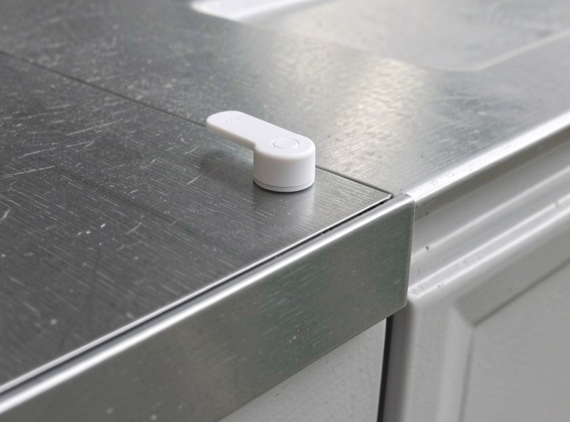 Wireless tilt sensor mounted on the top panel of a sectional garage door