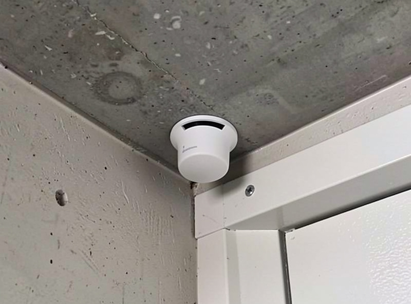 mmWave presence sensor mounted in a garage ceiling corner